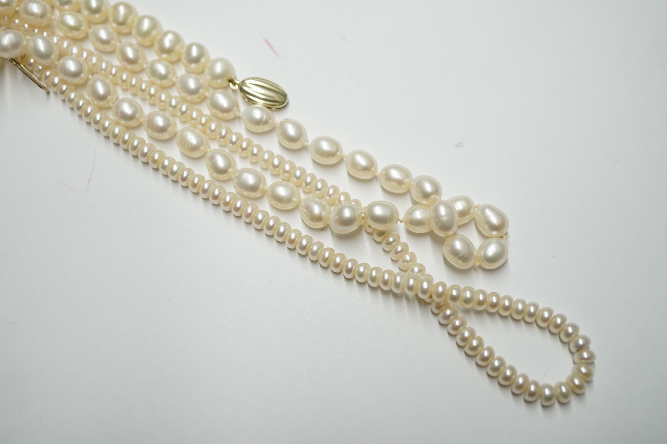 Three assorted modern cultured pearl necklaces, two with 9k clasps, longest 64cm. Condition - fair